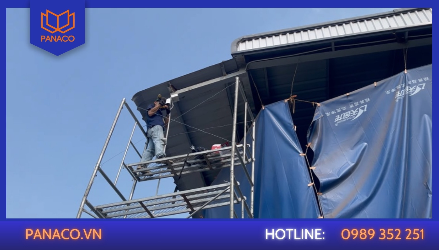 Kỹ thuật viên căn chỉnh góc quan sát camera tại khu vực cửa xưởng