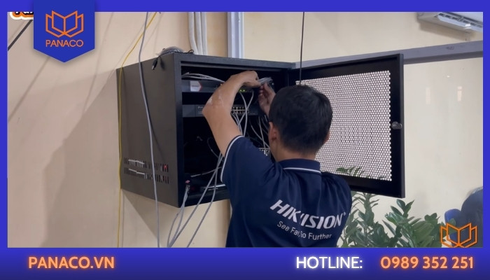 Kỹ thuật viên bấm đầu mạng và sắp xếp đường dây tín hiệu bên trong tủ rack
