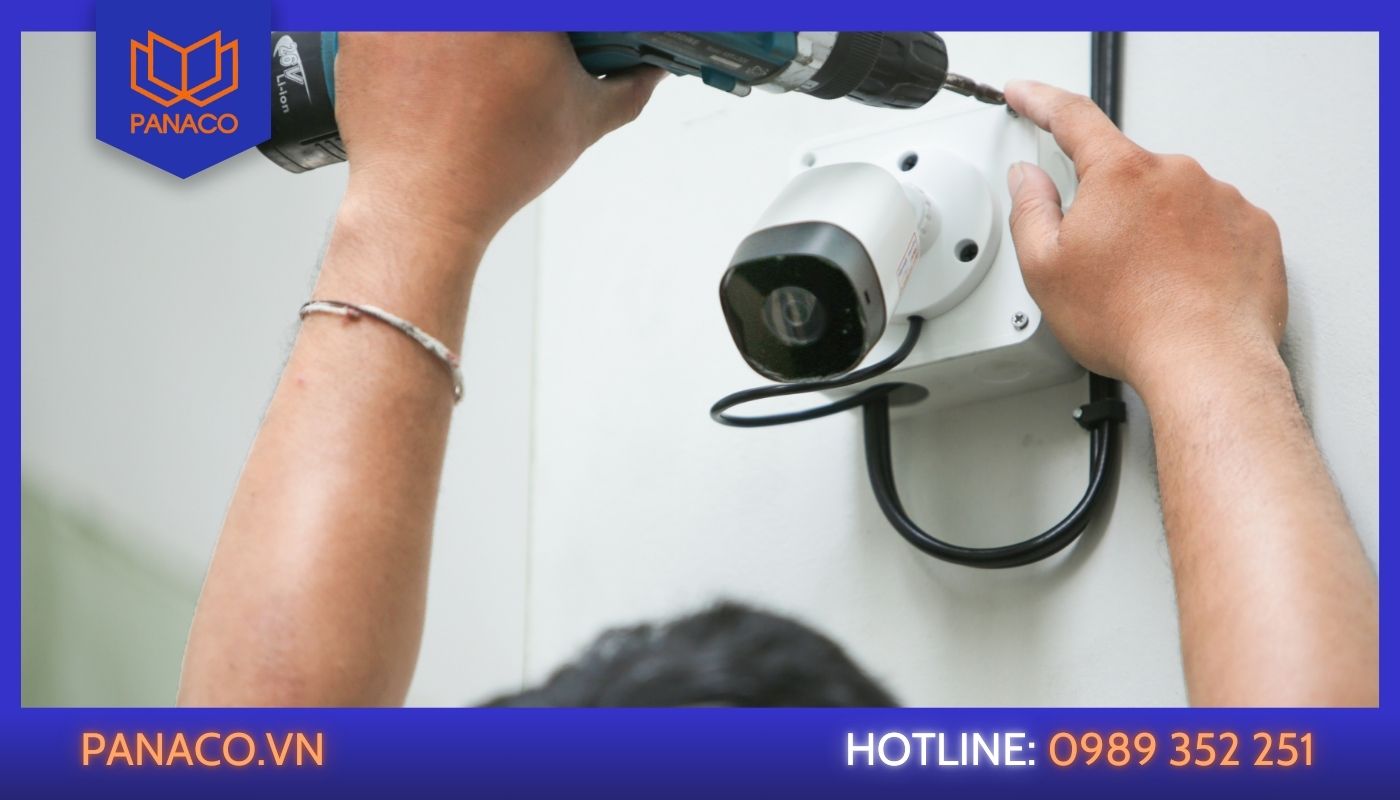 Thợ bắt vít cố định chân đế camera ngoài trời lên tường bê tông